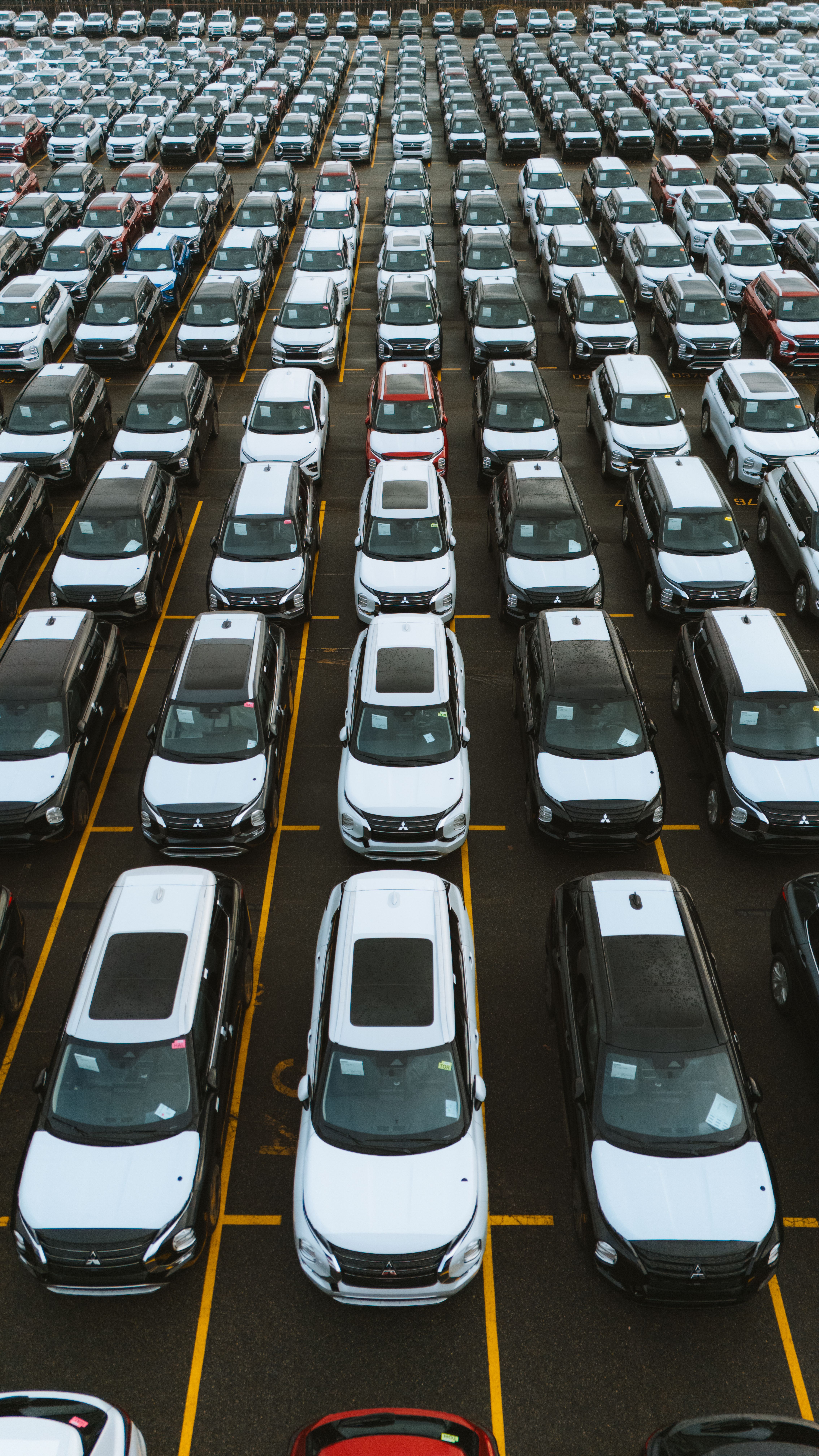 Fileira de carros 0km estacionados em pátio de concessionária