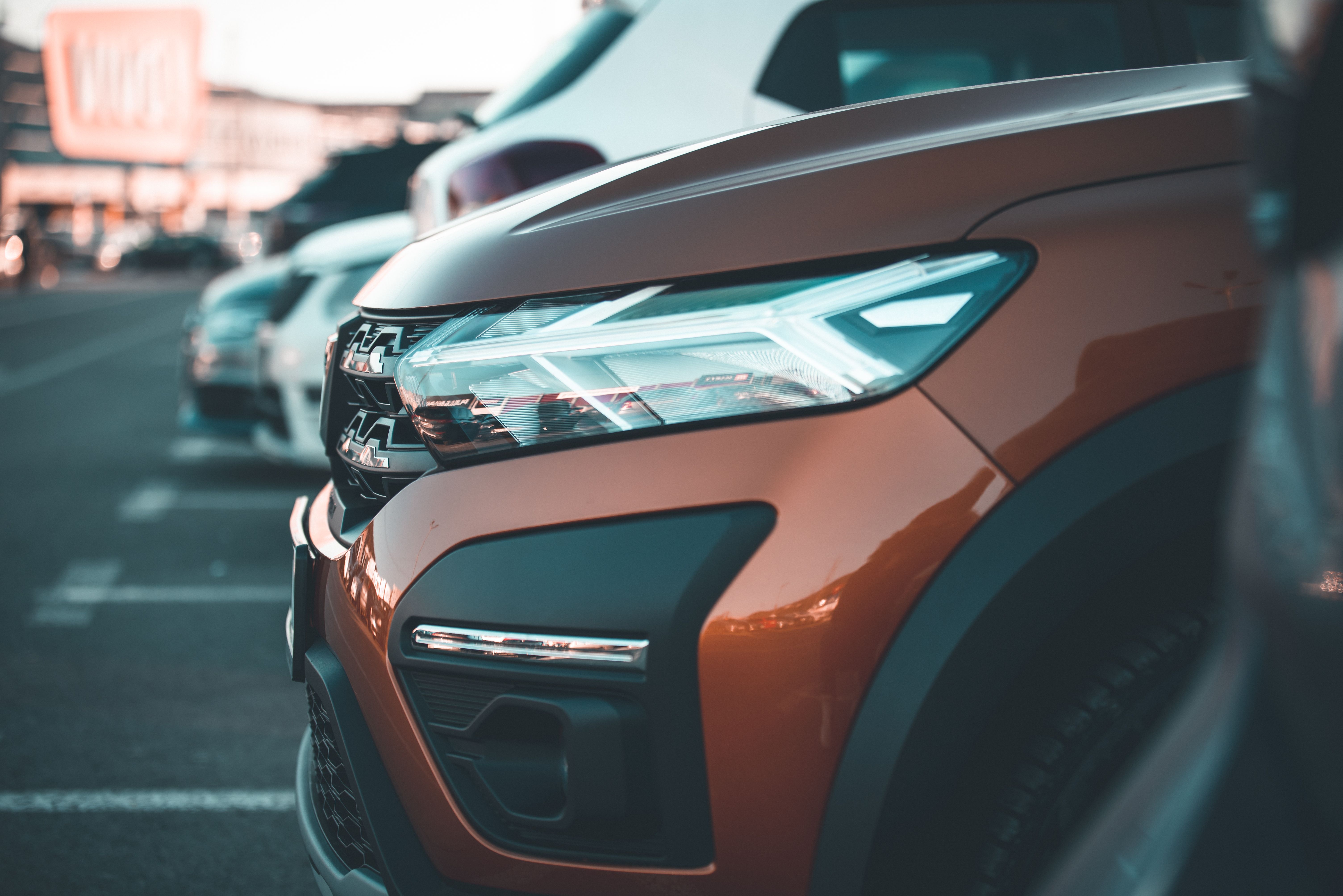 Vista aérea de cruzamento urbano noturno com vários carros de aplicativo e um táxi — representando o excesso de oferta nas ruas